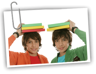 Two twin boys holding books on their heads and smiling