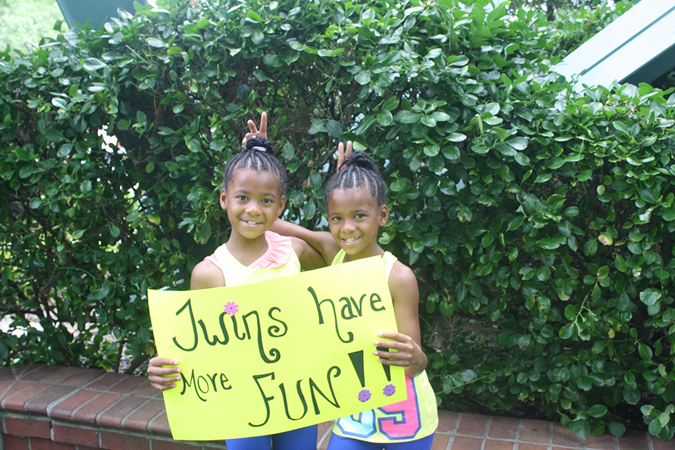 Twin girls holding up a sign 