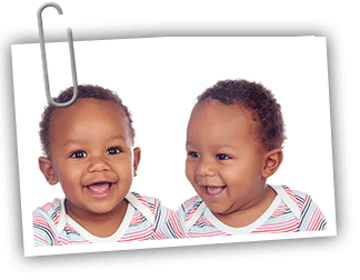 Two twin African American baby boys laughing