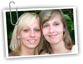 Young adult female twin pair smiling at the camera