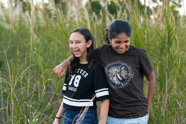 Fraternal preteen twin sisters in a field